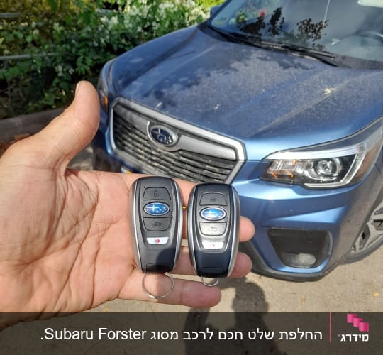 שני מפתחות רכב חכמים ביד מול רכב כחול